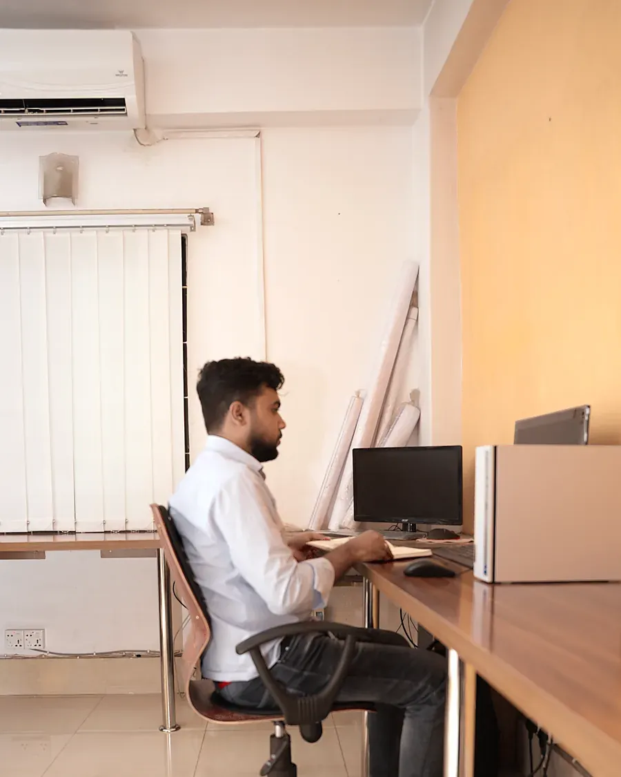 A person working at a quiet workstation by a window